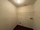 A utilitarian laundry room with hookups and shelving for storage at 4500 Nocohoma Bnd, Douglasville, GA 30135