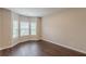 Sun-filled living room featuring large bay windows, neutral walls, and hardwood floors at 4500 Nocohoma Bnd, Douglasville, GA 30135