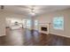 Open concept living room connects to a kitchen and features hardwood floors, fireplace and ceiling fan at 4500 Nocohoma Bnd, Douglasville, GA 30135