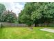 Fenced backyard with lawn and flowering trees at 1265 Birchwood Ln, Roswell, GA 30076