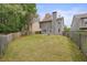 Large backyard featuring a spacious green lawn, privacy fence, and mature trees at 1265 Birchwood Ln, Roswell, GA 30076