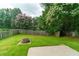 Spacious backyard with green lawn, stone fire pit, and wooden fence at 1265 Birchwood Ln, Roswell, GA 30076