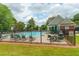 In-ground pool with chairs, tables, umbrellas, and fencing at community center at 1265 Birchwood Ln, Roswell, GA 30076