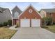 Charming exterior view showcasing a two-story house with a two-car garage and well-kept landscaping at 1265 Birchwood Ln, Roswell, GA 30076