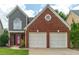 Beautiful front view of the two-story home featuring a brick facade and a two-car garage at 1265 Birchwood Ln, Roswell, GA 30076
