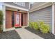 Inviting front porch with a decorative red door, dark shutters, and manicured landscaping at 1265 Birchwood Ln, Roswell, GA 30076