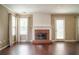 Spacious living room with a brick fireplace, hardwood floors, and bright natural light from the windows at 1265 Birchwood Ln, Roswell, GA 30076