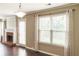 Well-lit living room with hardwood floors, a brick fireplace, and stylish curtains framing the large window at 1265 Birchwood Ln, Roswell, GA 30076