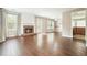 Open living room featuring hardwood floors, a cozy brick fireplace, and seamless access to the kitchen at 1265 Birchwood Ln, Roswell, GA 30076