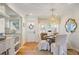 Bright dining area with a stylish chandelier, white chairs, and a view of the adjacent kitchen at 2530 Parkdale Pl, Atlanta, GA 30305