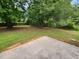 Spacious backyard featuring a concrete patio area, mature trees, and ample green space for outdoor activities at 263 Northwind Dr, Stockbridge, GA 30281