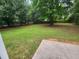 Large, grassy backyard with mature trees and a patio at 263 Northwind Dr, Stockbridge, GA 30281