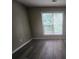 Bedroom with wood-look flooring and natural light from a large window at 263 Northwind Dr, Stockbridge, GA 30281