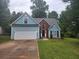 Charming home with a light blue exterior, brick accents, a well-manicured lawn and a two-car garage at 263 Northwind Dr, Stockbridge, GA 30281
