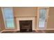 Elegant white fireplace with marble hearth flanked by window and door, with gray vinyl flooring at 263 Northwind Dr, Stockbridge, GA 30281