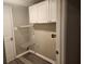 Practical laundry room with white cabinets, shelving, and washer/dryer hookups at 263 Northwind Dr, Stockbridge, GA 30281