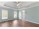 Bedroom featuring tray ceiling, fan, and multiple windows at 3183 Robinwood Trl, Decatur, GA 30034