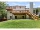 Backyard view of a two-story home with multiple decks, lush greenery and manicured lawn at 3183 Robinwood Trl, Decatur, GA 30034