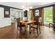 Dark-walled dining room with hardwood floors, classic decor, and multiple windows offering natural light at 3380 E Wood Valley Rd, Atlanta, GA 30327