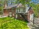 Classic brick home featuring a well-manicured lawn and a staircase leading to an upper-level balcony at 3380 E Wood Valley Rd, Atlanta, GA 30327