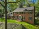 Charming brick home featuring a well-manicured lawn and a beautiful blue entryway, complemented by lush greenery all around at 3380 E Wood Valley Rd, Atlanta, GA 30327