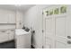 Bright laundry room with white cabinets and a modern, front-loading washer and dryer at 3380 E Wood Valley Rd, Atlanta, GA 30327