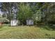 Spacious backyard featuring two storage sheds, mature trees and green lawn at 4164 Weston Dr, Powder Springs, GA 30127