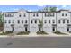 Row of modern townhomes with white facades, black accents, garages, and well-maintained landscaping at 148 Werner Brook Sw Way, Atlanta, GA 30354