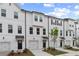 Elegant townhouses featuring white siding, black doors, attached garages, and manicured front lawns at 148 Werner Brook Sw Way, Atlanta, GA 30354