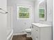 Bright bathroom featuring a vanity with storage, toilet, tub, and window offering natural light at 2307 Woodridge Dr, Marietta, GA 30066