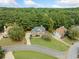Aerial view showcasing a well-maintained brick home with lush lawn, mature trees, and a circular driveway at 374 Meadowmeade Cv, Lawrenceville, GA 30043