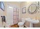 Bathroom featuring decorative oval mirror, pedestal sink, and shower with curtain at 374 Meadowmeade Cv, Lawrenceville, GA 30043