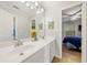 Bathroom featuring a double vanity and a view into a bedroom with natural lighting at 374 Meadowmeade Cv, Lawrenceville, GA 30043