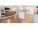 Bright, open kitchen featuring a breakfast bar that connects to a living area with hardwood floors at 374 Meadowmeade Cv, Lawrenceville, GA 30043