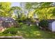 A large yard featuring a small deck, privacy fence, storage building, and mature trees at 479 Shannon Sw Dr, Atlanta, GA 30310