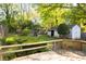 Spacious backyard featuring a wooden deck, lush greenery, flower bushes, storage shed and privacy fence at 479 Shannon Sw Dr, Atlanta, GA 30310