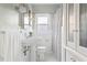 All-white bathroom with pedestal sink, tiled floors, and a shower and tub combo at 479 Shannon Sw Dr, Atlanta, GA 30310