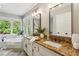 Bright bathroom with dual sinks, granite countertops, and a separate soaking tub at 550 Ambergate Ct, Roswell, GA 30076