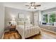 Charming bedroom features a window seat, hardwood floors, and a decorative white metal bed frame at 550 Ambergate Ct, Roswell, GA 30076