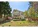 Back exterior view of the home with multi-level decks, patio, and a spacious yard at 550 Ambergate Ct, Roswell, GA 30076