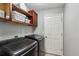 Well-equipped laundry room featuring modern black washer/dryer and wooden shelves and cabinets for ample storage at 550 Ambergate Ct, Roswell, GA 30076