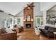Cozy living room featuring a brick fireplace, hardwood floors, and plenty of natural light at 550 Ambergate Ct, Roswell, GA 30076