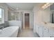 Bright bathroom featuring a soaking tub, glass shower, double vanity, and natural light at 119 Felicity Pike, Locust Grove, GA 30248