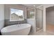 Bright bathroom featuring a soaking tub, glass shower, double vanity, and natural light at 119 Felicity Pike, Locust Grove, GA 30248