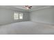 A spacious bedroom features a ceiling fan and bright windows overlooking the yard at 119 Felicity Pike, Locust Grove, GA 30248