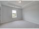 A well-lit bedroom with neutral carpet, trim detail, and a bright window at 119 Felicity Pike, Locust Grove, GA 30248