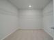 A walk-in closet offers ample space with adjustable shelving and neutral carpet at 119 Felicity Pike, Locust Grove, GA 30248
