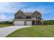 Beautiful two-story brick home with a three-car garage and well-manicured lawn on a sunny day at 119 Felicity Pike, Locust Grove, GA 30248