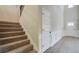 Bright foyer with carpeted staircase, and paneled walls leading to front door at 119 Felicity Pike, Locust Grove, GA 30248