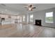 Open-concept living space with a fireplace, hardwood floors, and a modern kitchen at 119 Felicity Pike, Locust Grove, GA 30248